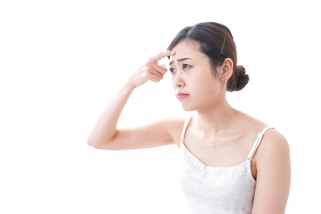 おでこにできたほくろを気にする女性